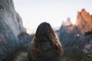 Woman cold and alone in rocky mountain barrenness.