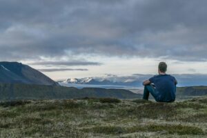 Man sitting alone on a rugged path contemplating