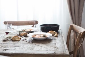 A dinner table set for two in quiet evening light, with no one seated